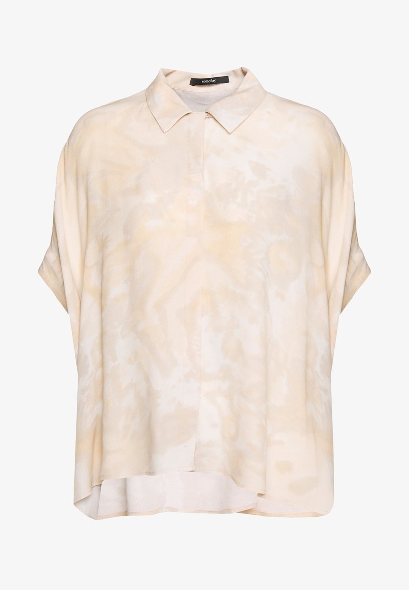 Ljusbeige kortärmad skjorta med en mjuk textur, med en knapp-ner krage och ett subtilt abstrakt mönster över hela.