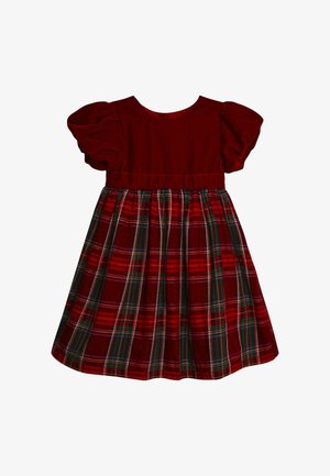 Rochie din catifea roșie cu mâneci bufante, având o fustă în carouri în nuanțe de roșu, verde și alb. Decolteu rotund clasic, talie strânsă pentru volum.