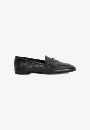 Black leather loafers with a flat sole, featuring a decorative strap and gold accents. The surface has a smooth texture with subtle creasing.