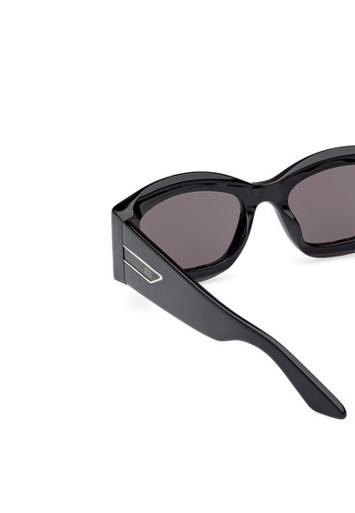 Czarne okulary przeciwsłoneczne o błyszczącym wykończeniu, kanciastym kształcie i ciemnych szkłach. Posiadają metaliczny akcent na zauszniku.