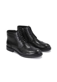 Stivali alla caviglia in pelle nera con lacci sul davanti, dettagli brogue decorativi e una cerniera laterale per un facile indossamento. Suola in gomma.