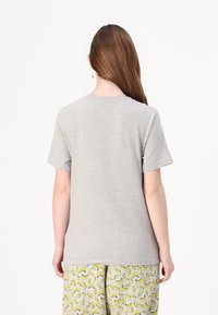 Pilkas trumpas rankovės T-shirt su apvalia kaklo iškirpte, pagamintas iš minkštos medžiagos. Nugarėlė yra paprasta, be matomų grafikų ar raštų.