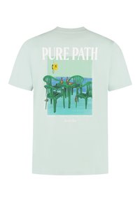 Mintgroene t-shirt met een afbeelding van groene plastic stoelen en een tafel met drankjes, gelabeld "Pure Path" in vetgedrukte witte letters.