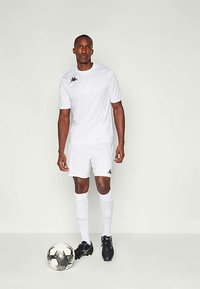 Baltas īsās piedurknes futbola kreklos un biksēs, ar melno Kappa logotipu. Melni futbola zābaki un bumba ar baltu sešu stūru rakstu pie kājām.