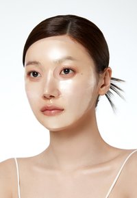 Masque en feuille transparent couvrant le visage, avec des découpes pour les yeux et la bouche. Texture lisse, apparence translucide, appliqué sur un fond couleur peau.