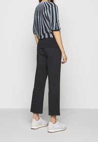 Czarny i niebieski w paski krótki rękaw, żebrowany dół. W połączeniu z szerokimi czarnymi spodniami i białymi trampkami, prezentującymi luźny fason.