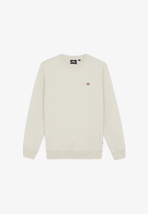 Cream-colored sweatshirt with a round neck. Features a small, colorful logo on the chest. Ribbed cuffs and hem. Soft texture.