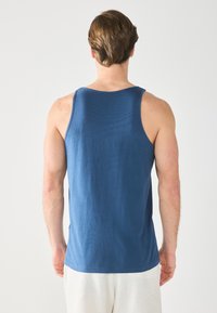 Canotta blu navy con un motivo a maglia testurizzata, caratterizzata da un collo rotondo e una vestibilità comoda. L'orlo è leggermente curvo.