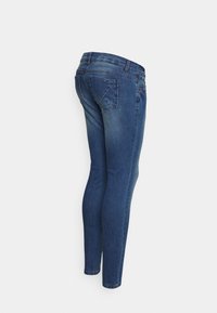 Jeans skinny feitos de denim azul escuro, com uma cintura de altura média, design tradicional de cinco bolsos e um leve desbotamento ao longo das pernas.
