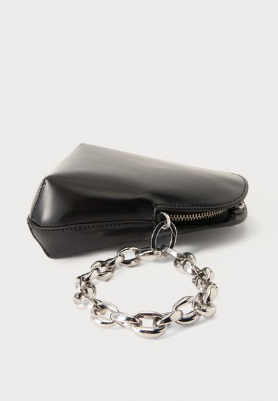 Pochette triangulaire en cuir noir avec une chaîne métallique argentée attachée à un curseur de fermeture éclair sur fond blanc.