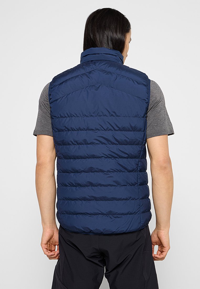 Marineblauer Steppwesten, ärmellos, leichtes Material, horizontal gestepptes Design, hoher Kragen, glatte Textur, minimale Akzente.