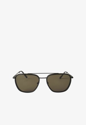 Lunettes de soleil noires avec une forme angulaire distinctive, verres foncés et monture en métal légère avec des branches fines et des détails subtils.