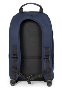 Mochila marinera con exterior de tela, correas ajustables y un asa en la parte superior. Cuenta con una gran abertura y un forro interior oscuro.