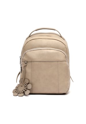 Mochila de cuero beige con bolsillo con cremallera en la parte frontal, asa superior y charm decorativo en forma de flor de cuero sujeto al tirador de la cremallera.