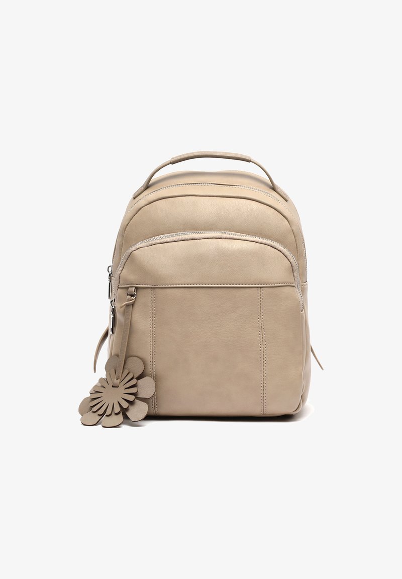 Beżowy skórzany plecak z przednią kieszenią zapinaną na zamek, górnym uchwytem oraz ozdobnym skórzanym breloczkiem w kształcie kwiatka przymocowanym do suwaka.