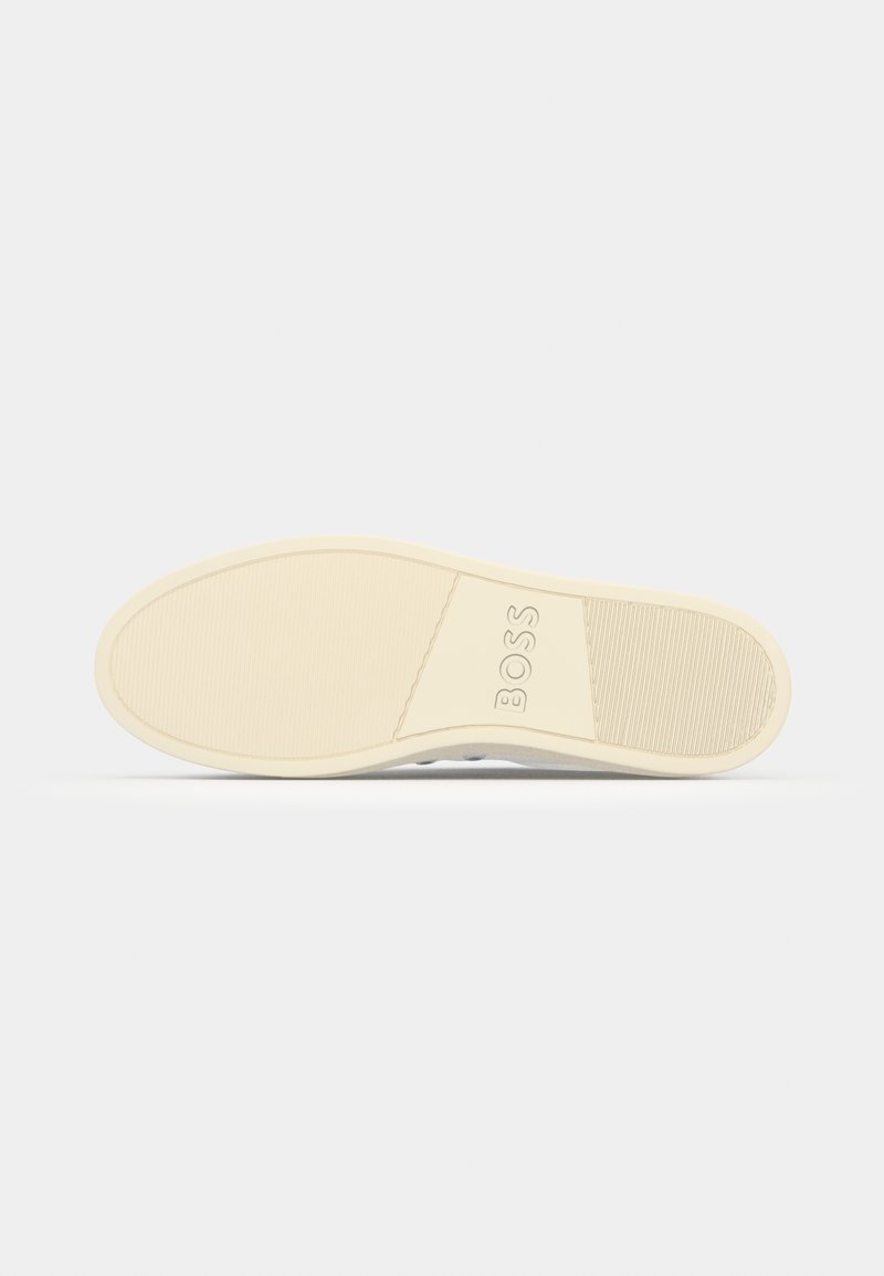 Semelle de chaussure avec un motif texturé, couleur beige clair, et logo en relief. Bords lisses et talon légèrement rehaussé.