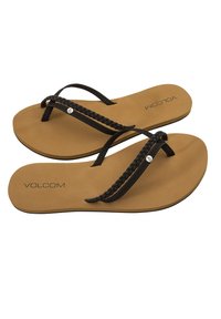 Infradito neri con cinturini intrecciati, soletta beige e logo "VOLCOM" impressa. Suola piatta con un motivo di battistrada minimale per la trazione.