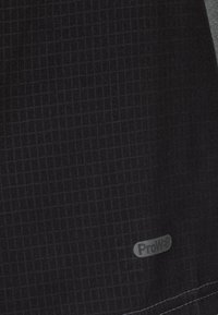 Tela negra con un patrón de cuadrícula texturizada, que presenta una sutil etiqueta ProW3. El material parece duradero y probablemente ligero.
