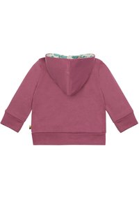 Felpa bordeaux con una consistenza morbida, dotata di cappuccio e polsini a coste. La fodera interna presenta un motivo blu chiaro con vortici.