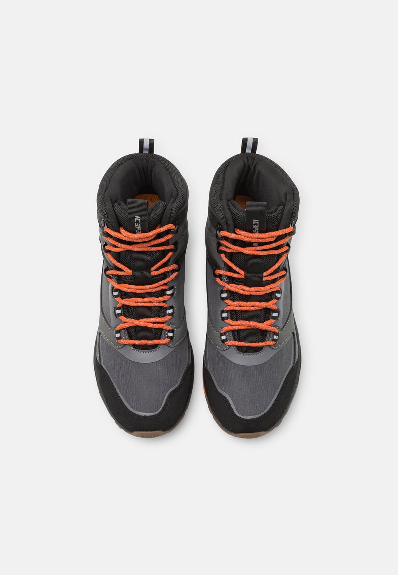 Półwysokie buty trekkingowe z szaro-czarną syntetyczną cholewką, pomarańczowymi sznurówkami, teksturowaną podeszwą oraz wyściełanym kołnierzem dla wygody i wsparcia.