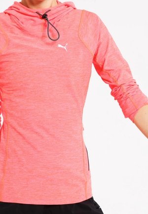 Helles Korallenrot Puma-Hoodie mit langen, hochgeschobenen Ärmeln, verstellbarem schwarz-weißem Kordelzug am Kragen, getragen von einer Person.