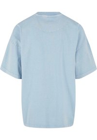 T-shirt surdimensionné bleu clair avec des manches courtes, fabriqué en coton doux. Doté d'un col rond et d'une texture lisse et unie.