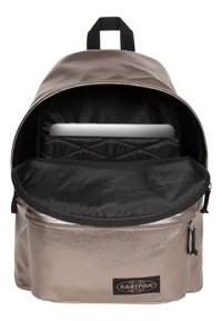 Metaliczny srebrny plecak z czarnym wnętrzem. Posiada główną komorę oraz wyściełaną kieszeń na laptopa. Łatka z logo na przedniej kieszeni.