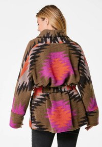 Übergroßer Cardigan in Braun mit bunten Zickzackmustern in Pink, Orange und Schwarz. Verfügt über eine taillierte Taille und weite Ärmel.