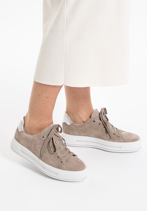 Light brown suede sneakers with white rubber soles, featuring a smooth silver accent at the heel and classic lace-up design.