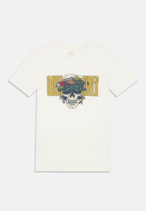 Bijela majica kratkih rukava s grafikom lubanje koja nosi sunčane naočale ispunjene tropskim biljkama i zalaskom sunca, s žutim tekstom "Quiksilver" iznad.