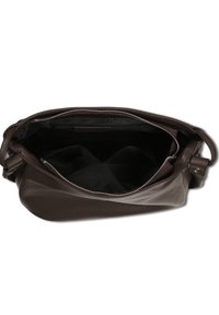 Braune Ledertasche mit strukturierter Oberfläche, ausgestattet mit einem Reißverschluss und einem dunklen Innenraum. Zwei Innenfächer zur Organisation.