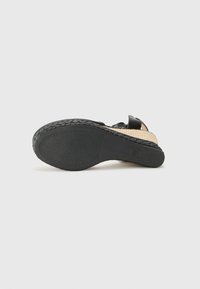 Schwarze Sandale mit einer Espadrille-Sohle. Verfügt über eine geflochtene Jute-Zwischensohle und eine strukturierte Gummisohle. Die Riemen sind aus weichem Material gefertigt.