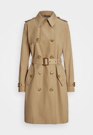 Beige trench coat with a double-breasted design, gold buttons, shoulder epaulets, belted waist, and side pockets. Smooth fabric texture.