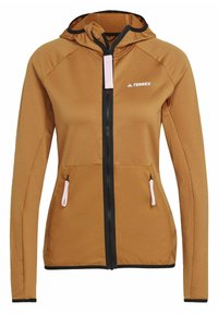 Veste softshell marron avec fermeture éclair et capuche, deux poches avant zippées, fermeture éclair noire et logo blanc "Terrex" sur la poitrine.