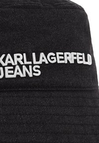 Chapéu bucket de denim preto com o logótipo em relevo prateado "KARL LAGERFELD JEANS", tecido texturizado com nervuras verticais distintas.