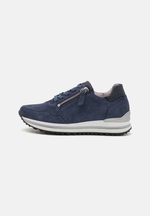 Sneaker in suede blu navy con piccole perforazioni, zip laterale, punta testurizzata, suola imbottita e intersuola bianca a contrasto.