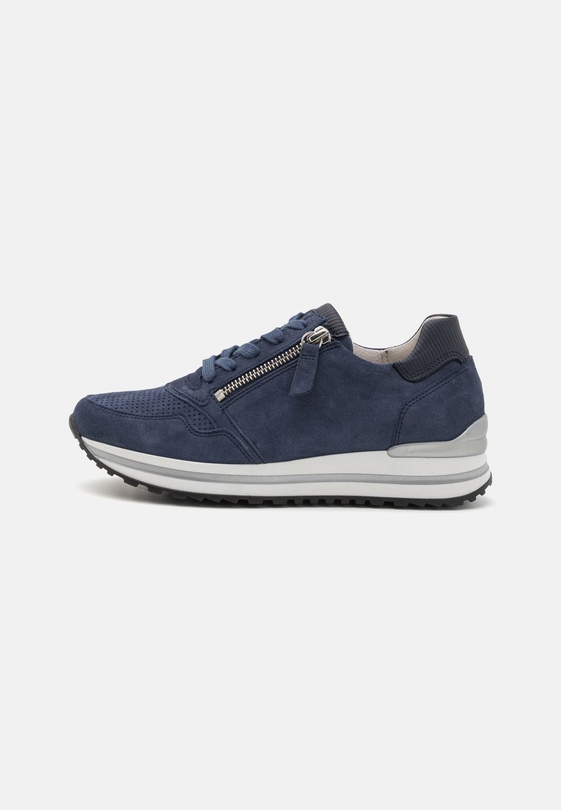 Baskets en suède bleu marine avec de petites perforations, une fermeture éclair sur le côté, une coque de protection texturée, une semelle rembourrée et une semelle intermédiaire blanche contrastante.