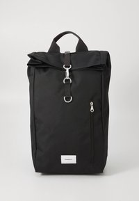 Μαύρο σακίδιο κατασκευασμένο από ανθεκτικό ύφασμα, με σχεδιασμό τύπου roll-top, πάνω χερούλι, μπροστινή τσέπη με φερμουάρ και ασημένιες διακοσμητικές λεπτομέρειες.