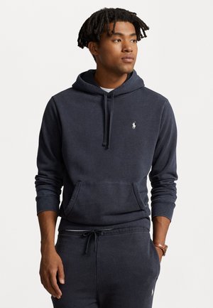 Navyblauwe hoodie, gemaakt van zacht stof, met een voorzak, ribgebreide manchetten en een klein geborduurd logo op de borst.