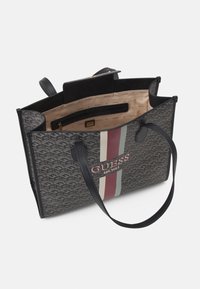 Harmaa kuvioitu kangaskassi mustilla nahkaosilla, jossa on punavalkoraidallinen kuviointi. Sisällä on taskuja ja merkkipainettu vuori.