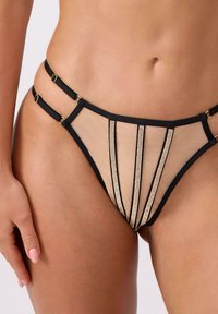 Czarne siateczkowe majtki od bikini z niskim stanem, podwójnymi bocznymi paskami i pionowymi ozdobami z kryształków, noszone na talii i biodrach osoby.