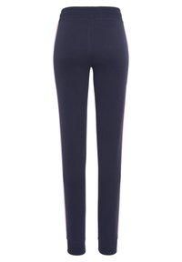 Dunkelblaue Sporthosen aus weichem Stoff, mit schmalem Schnitt, gerippten Bündchen und rosa seitlichen Streifen.