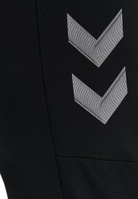 Schwarze Sportleggings aus strukturiertem Stoff mit einem grauen Chevron-Muster. Glattes Material mit einem Netzakzent für Atmungsaktivität.