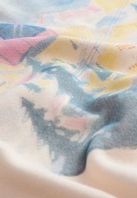 Kokvilnas audums ar mīkstu faktūru, kas rotāts ar daudzkrāsainu abstraktu rakstu zilā, rozā un dzeltenā toņos.