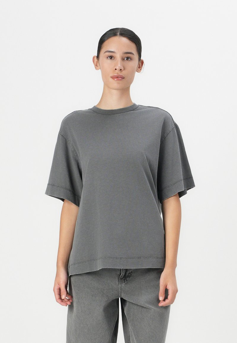 Grijze oversized t-shirt van zachte katoen met een ronde halslijn en korte mouwen; heeft een relaxte pasvorm en subtiele stikseldetails.