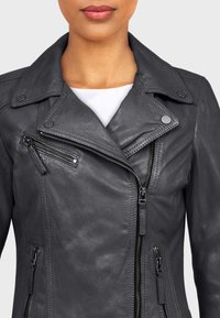 Šedá kožená motocyklová bunda s asymetrickým zipsom, klopou na cvoky a diagonálnymi prednými vreckami so zipsom. Hladká textúra s jednofarebným dizajnom.