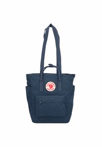 Borsa a spalla blu navy realizzata in tessuto resistente, dotata di doppi manici, tasca frontale con zip e dettaglio del logo circolare sul davanti.