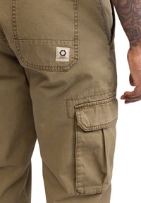 Cargo-Hosen aus olivgrünem Baumwollgemisch mit einer Seitentasche und einem Patch-Label. Mit verstärkten Nähten und einem lässigen Schnitt.