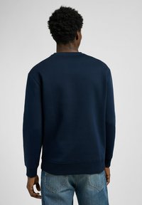 Marineblauwe sweatshirt met een ronde hals, lange mouwen en ribgebreide manchetten, met een zachte textuur en een eenvoudig ontwerp.