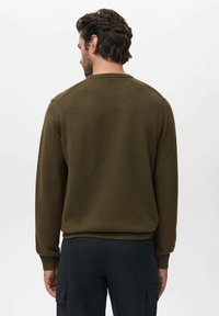 Pulover tricotat de culoare verde olive, cu mansete și tiv cu nervuri. Spatele are un guler rotund clasic și o textură netedă. Fără modele sau accente vizibile.
